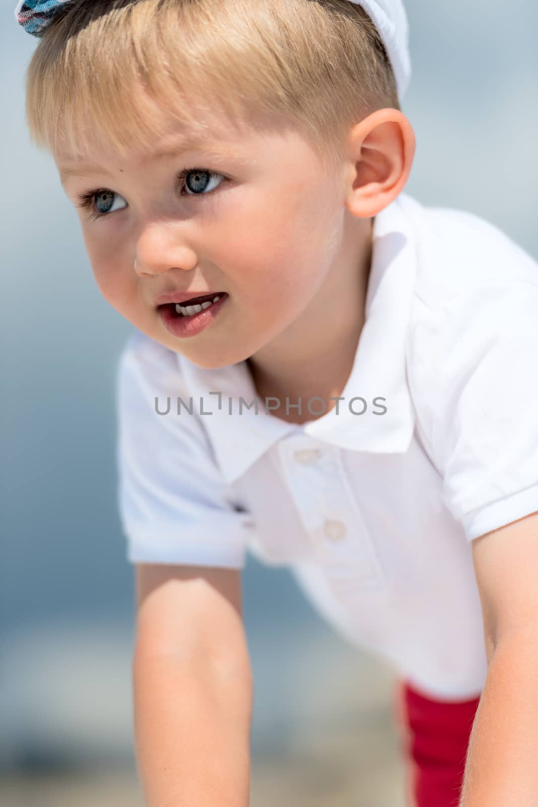 Little boy portrait in white polo shirt by Nanisimova