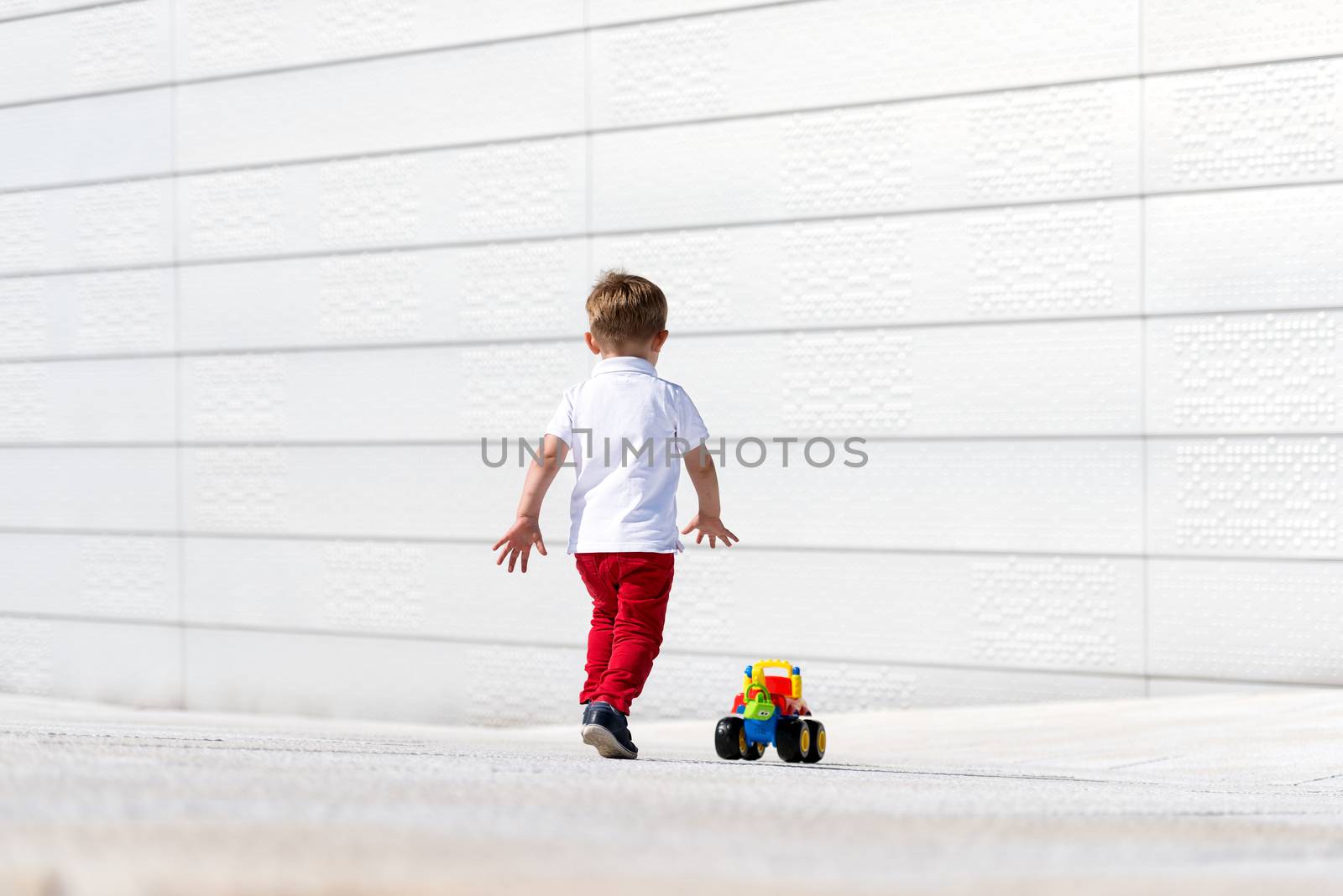 Little boy playing with toy car no face by Nanisimova