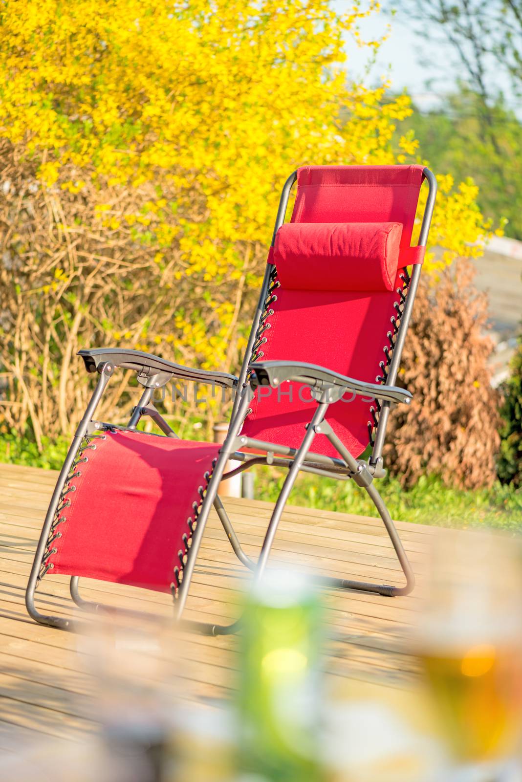 Folding red chair on backyard patio at fall day
