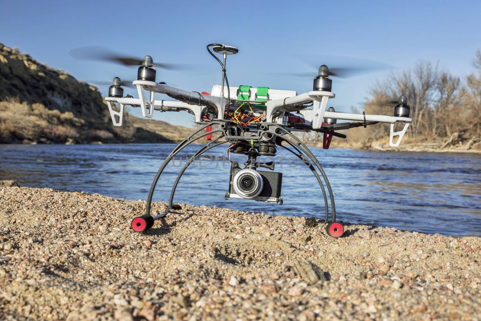 WILDCAT, CO, USA, March 9,  2015:  DJI F550 Flame Wheel  hexacopter drone landing with a camera on river shore.