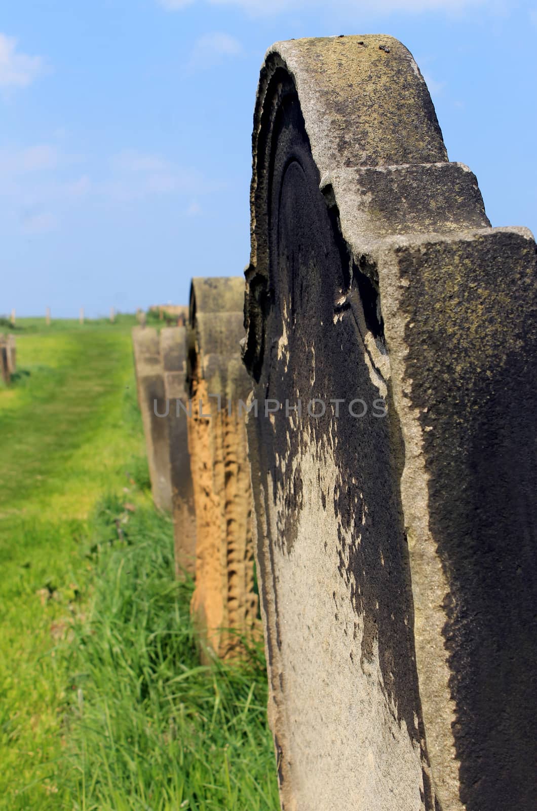 Scenic view of old gravestones in a rural cemetery with the focus on the stone in the foreground.