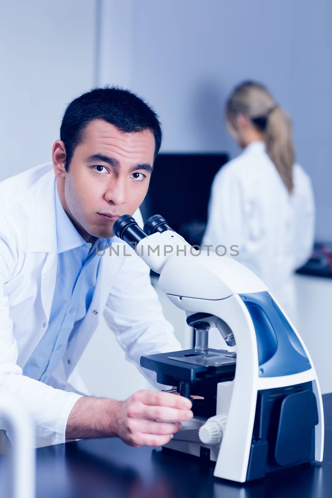 Science student working with microscope in the lab by Wavebreakmedia