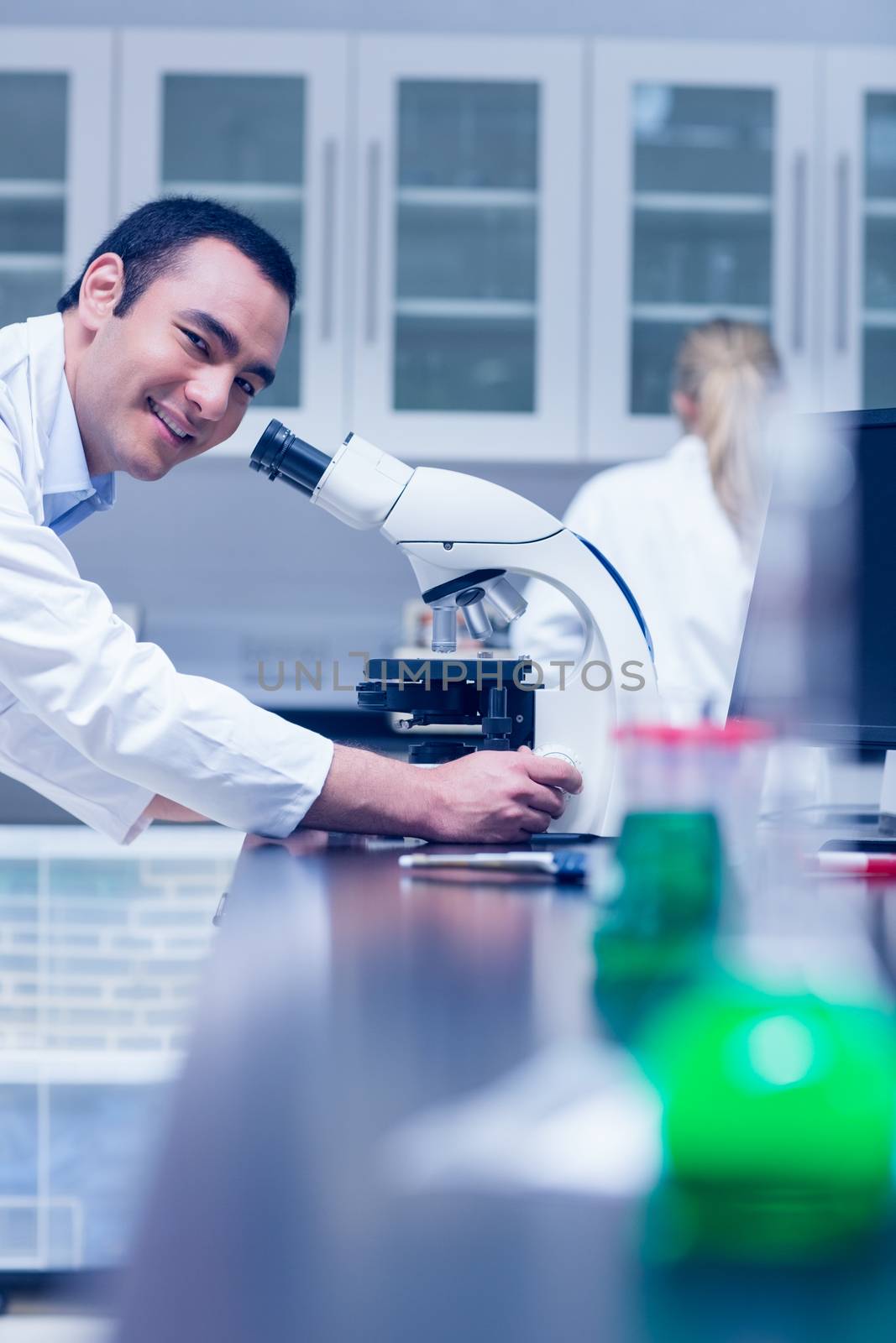 Science student working with microscope in the lab by Wavebreakmedia