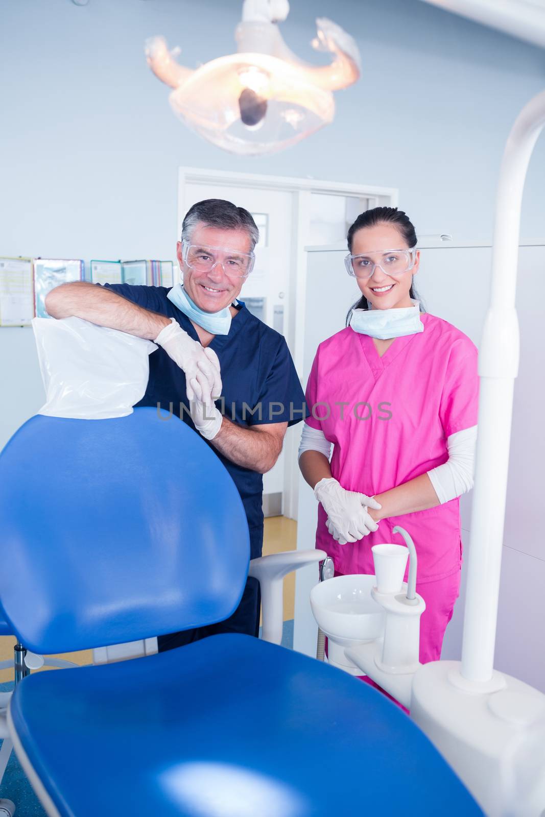 Smiling dentist and assistant with protective glasses by Wavebreakmedia