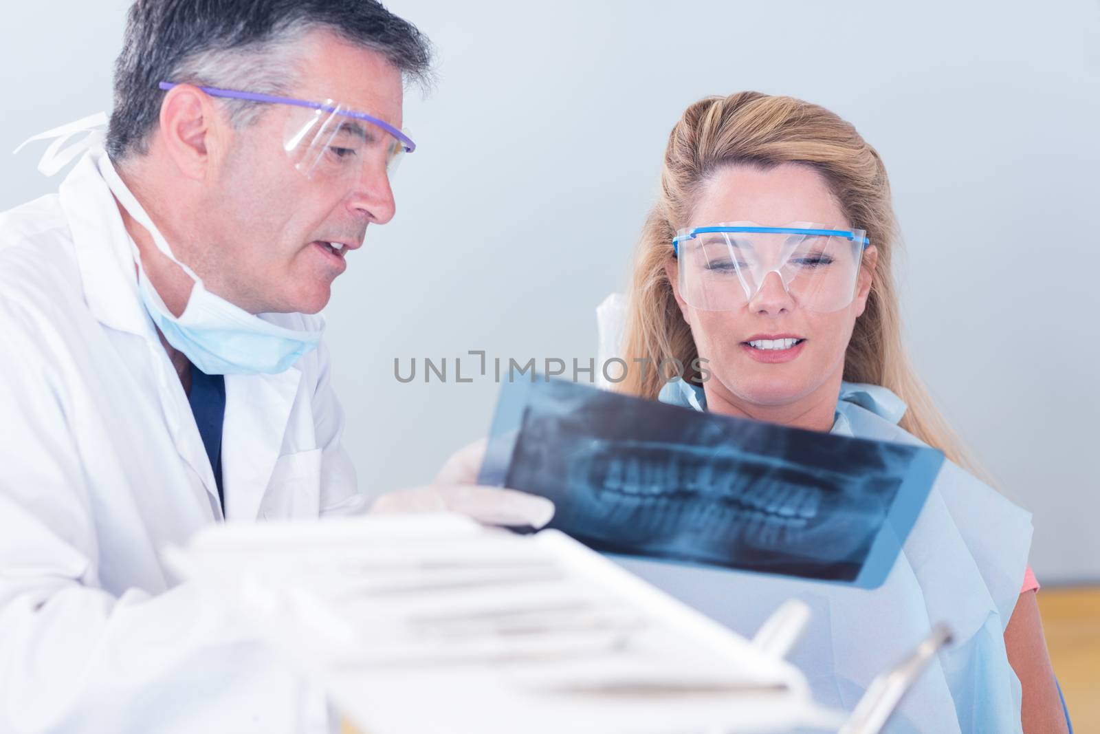 Dentist showing x-ray to his patient at the dental clinic