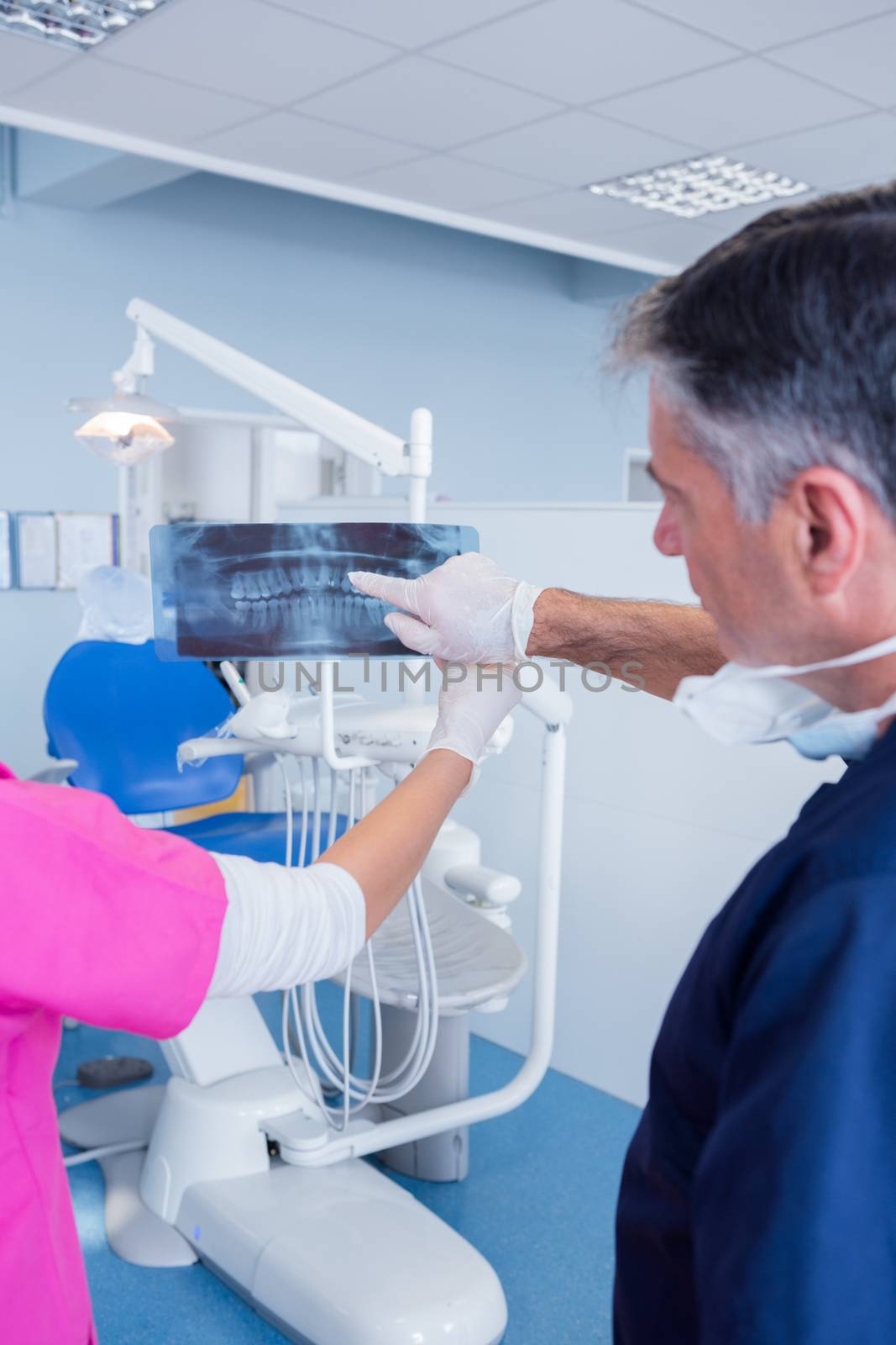 Dentist pointing something at x-ray by Wavebreakmedia