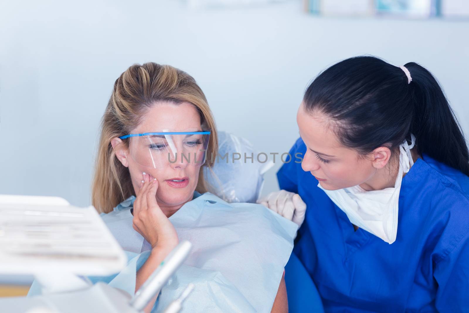 Dentist speaking with patient about toothache by Wavebreakmedia
