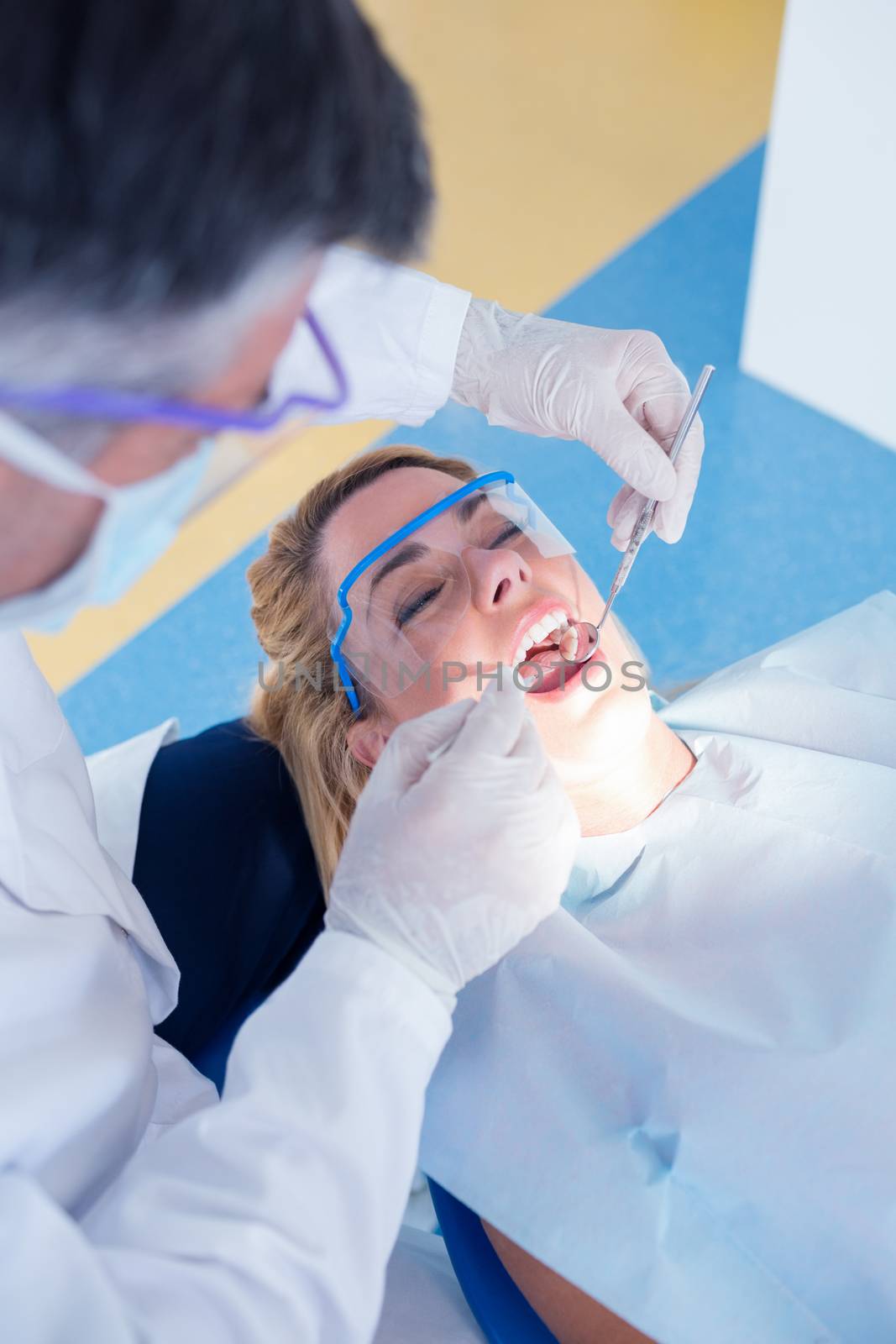 Dentist examining a patients teeth in the dentists chair by Wavebreakmedia