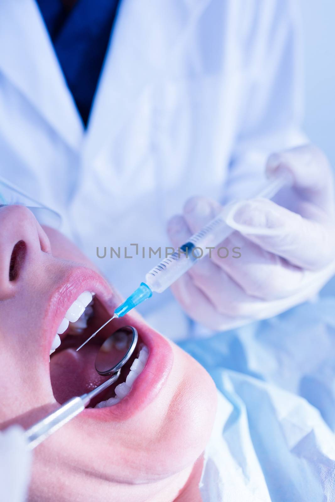Dentist about to give injection to patient at the dental clinic