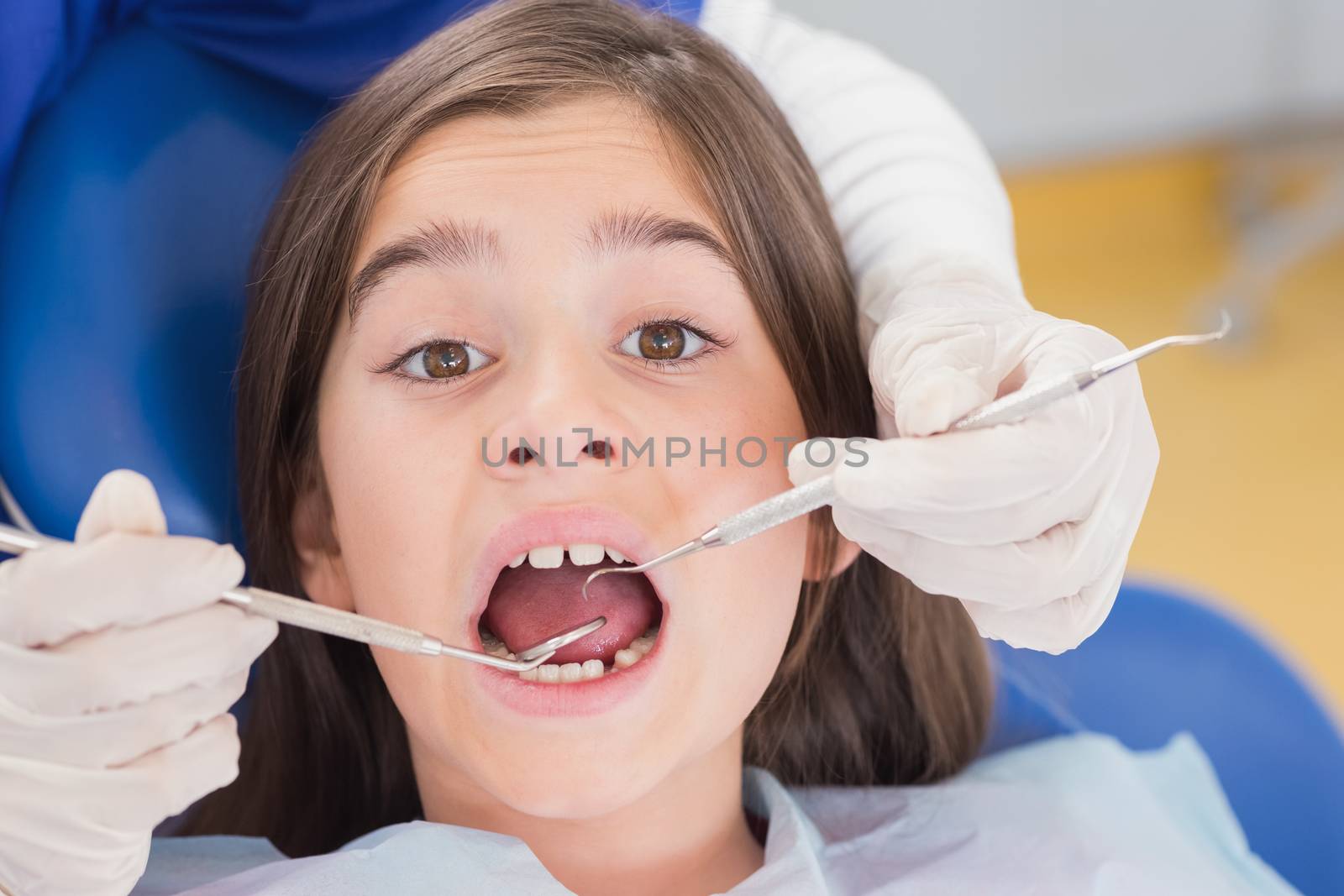 Portrait of a scared young patient in dental examination in clinic