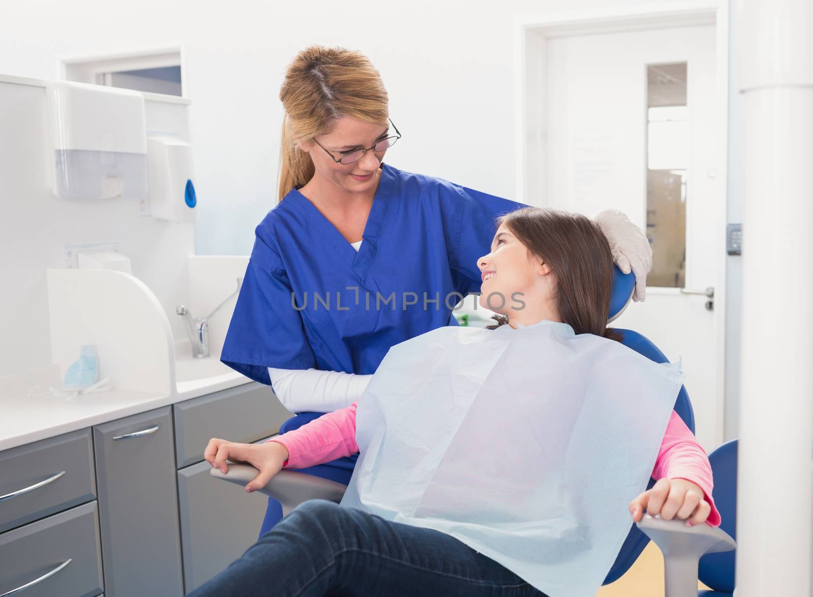 Smiling pediatric dentist with a happy young patient in dental clinic