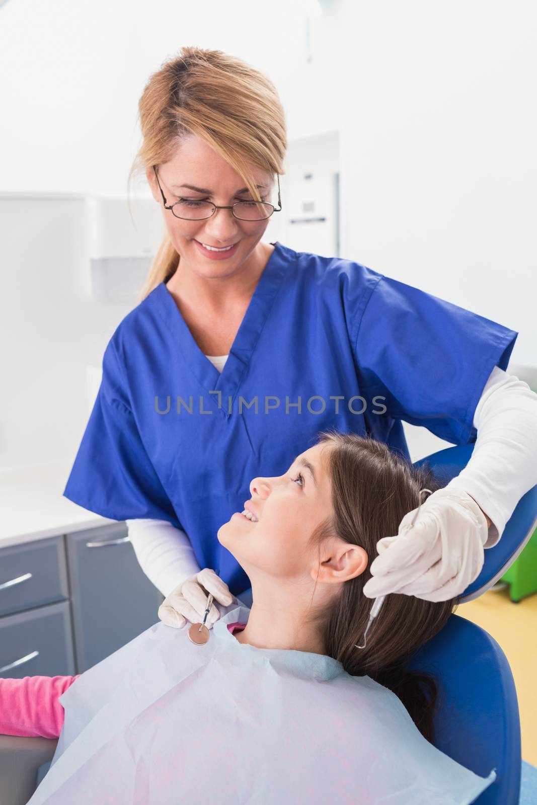Smiling pediatric dentist with a happy young patient in dental clinic