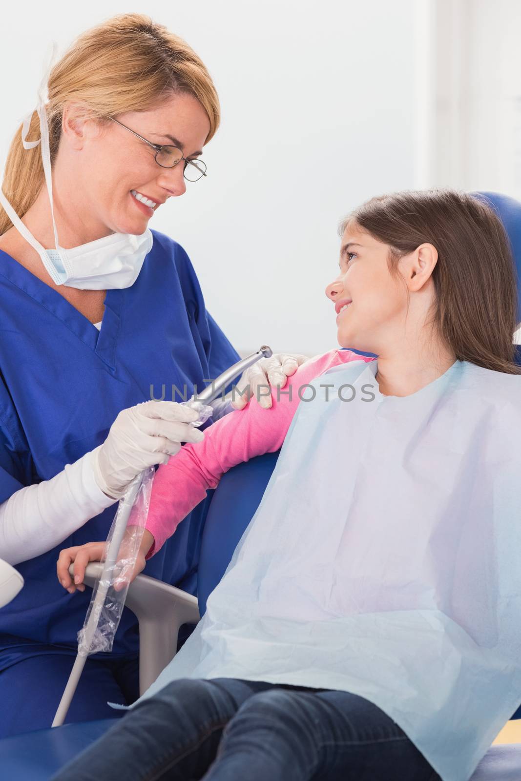 Smiling pediatric dentist reassuring her young patient by Wavebreakmedia