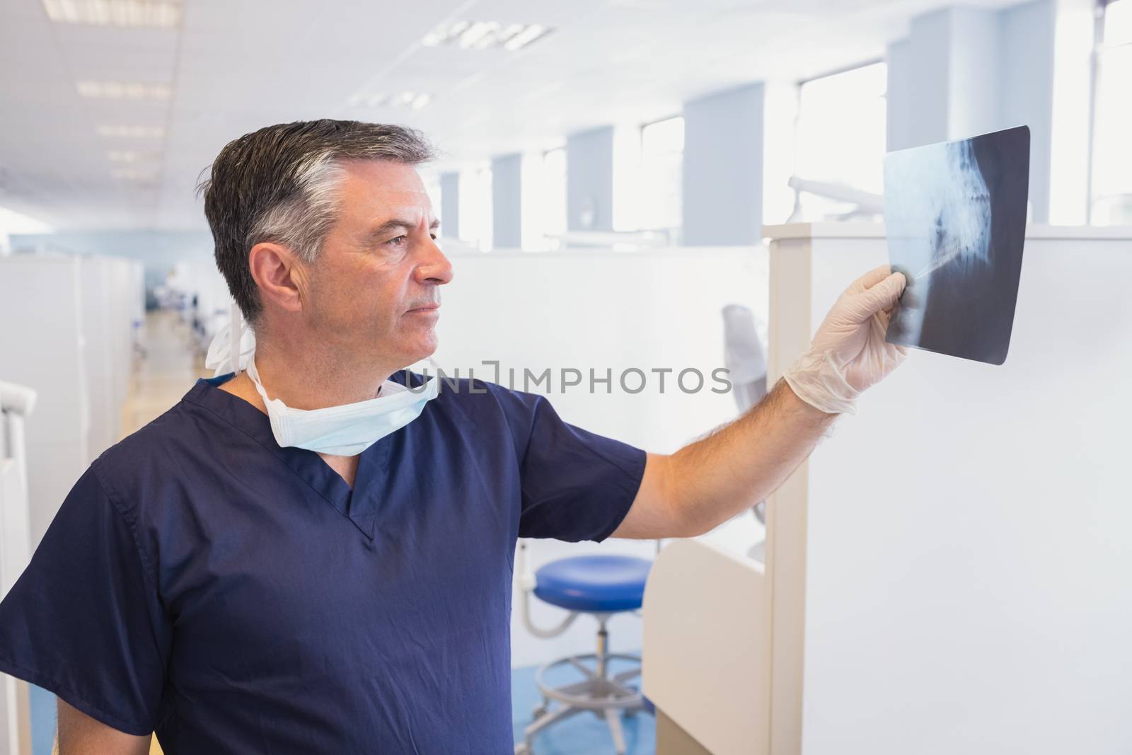 Happy dentist examining a x-ray by Wavebreakmedia