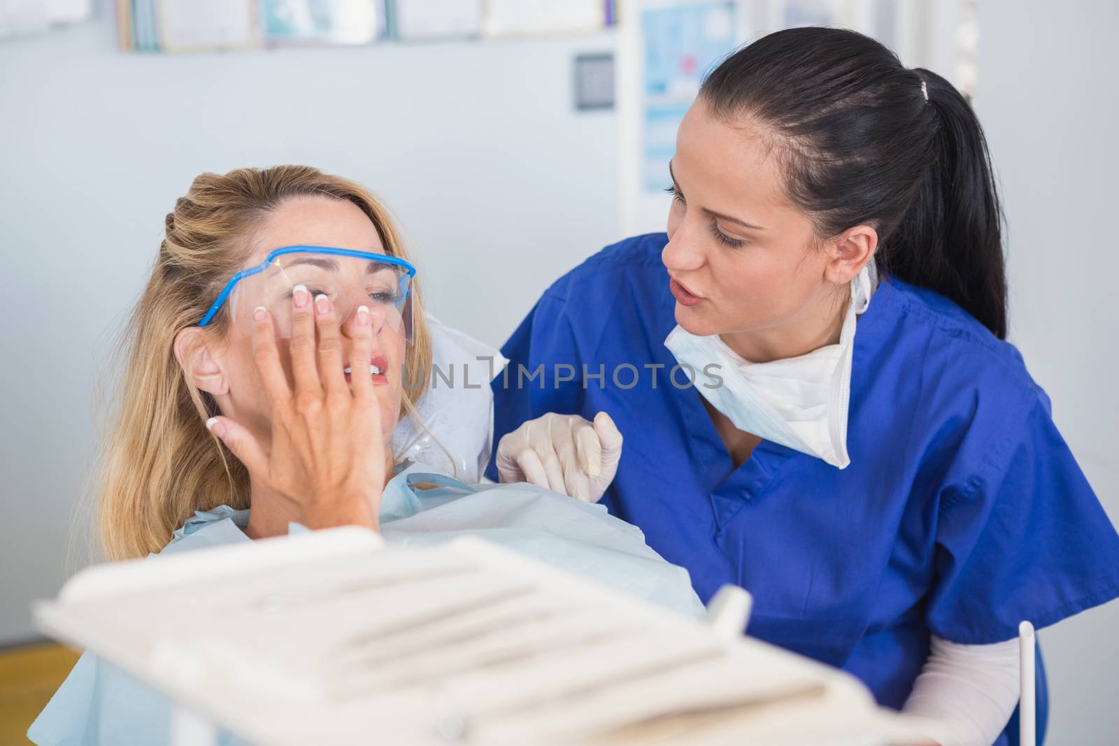 Patient and dentist talking about her toothache in dental clinic
