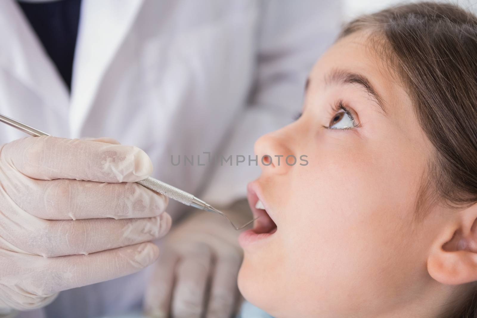 Pediatric dentist examining his nervous young patient by Wavebreakmedia