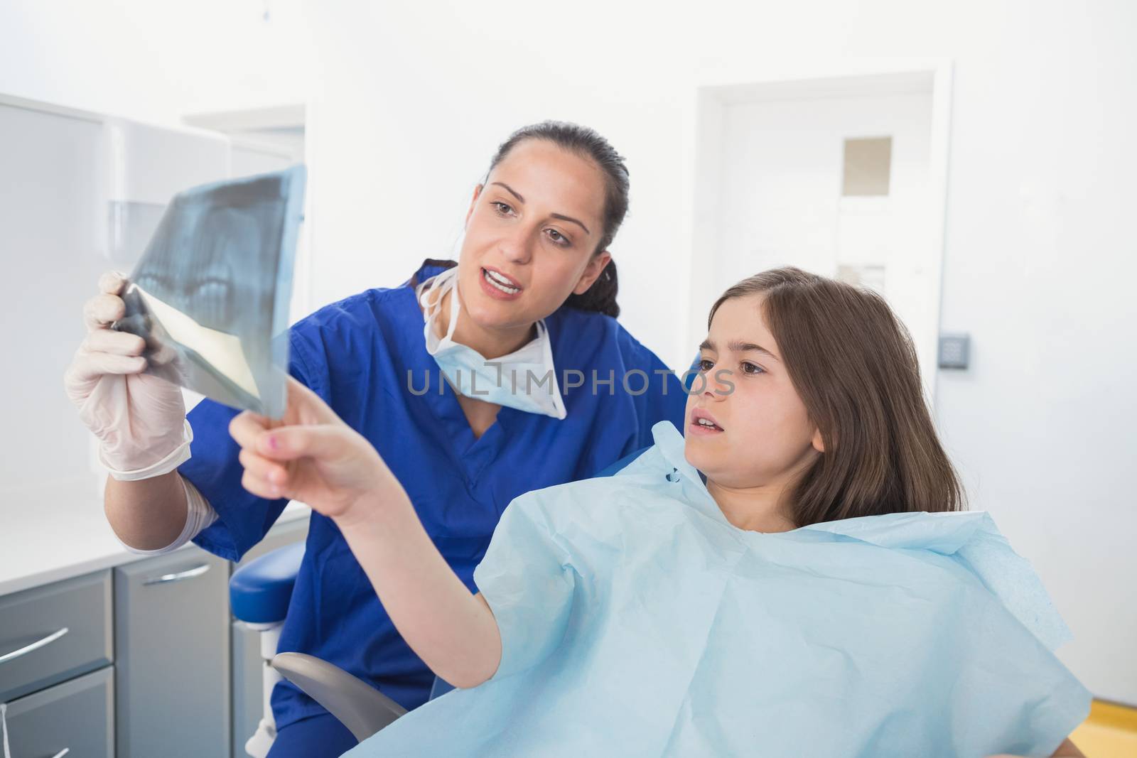 Pediatric dentist explaining to young patient the x-ray by Wavebreakmedia