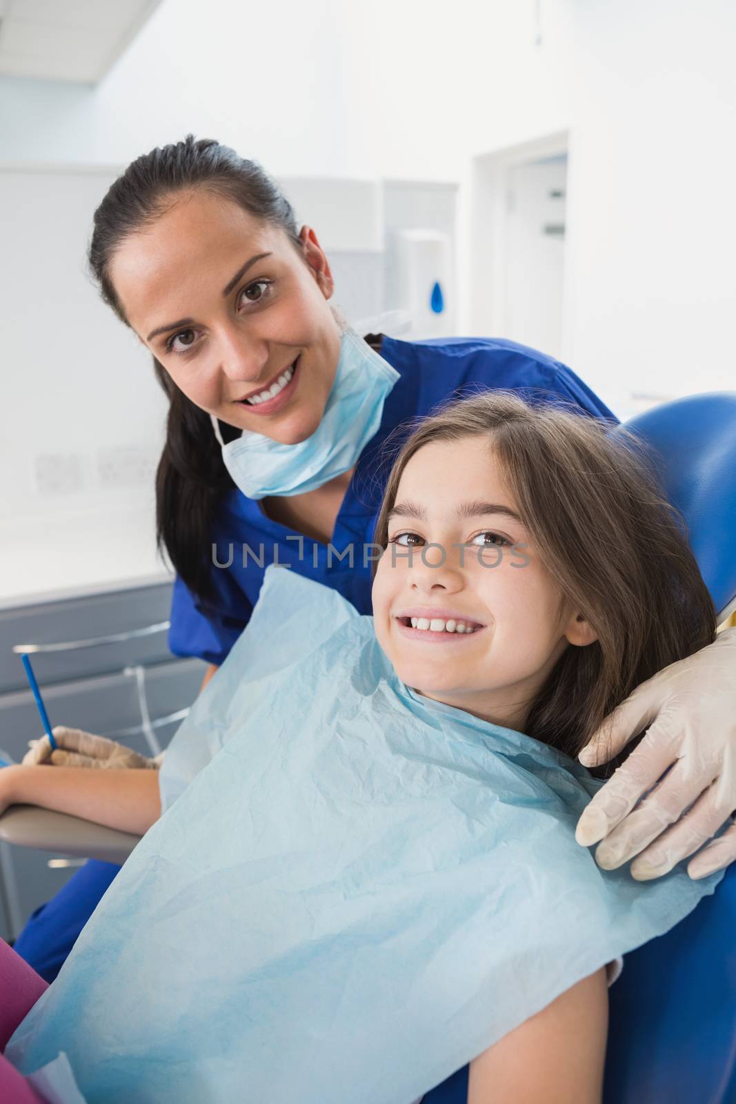Smiling pediatric dentist with a cute young patient by Wavebreakmedia