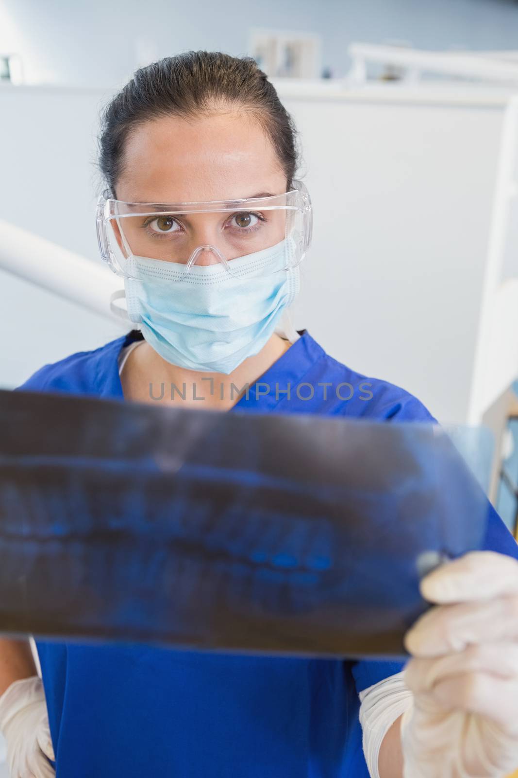 Dentist wearing surgical mask and safety glasses by Wavebreakmedia