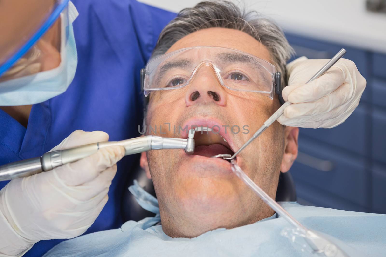 Dentist examining a patient with tools by Wavebreakmedia