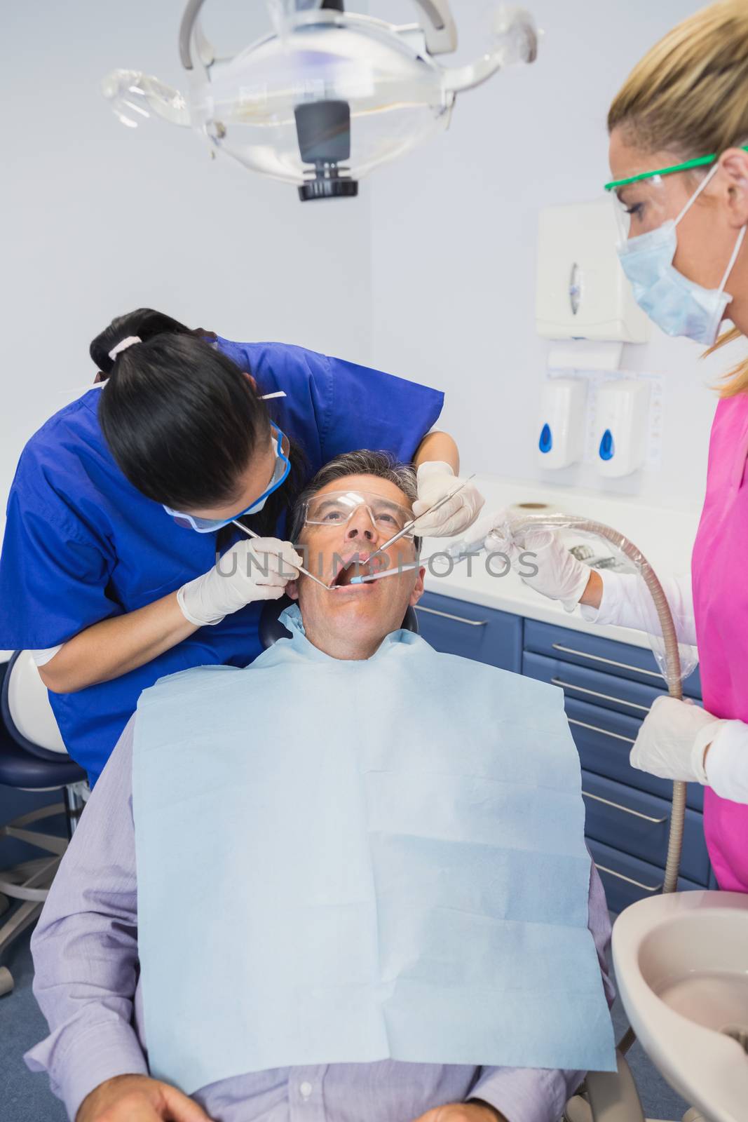 Dentist examining a patient  by Wavebreakmedia