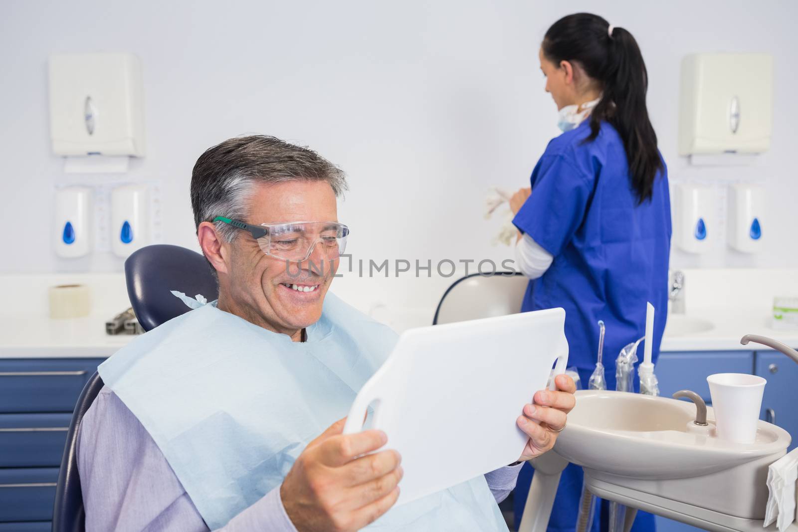 Smiling patient holding a mirror by Wavebreakmedia