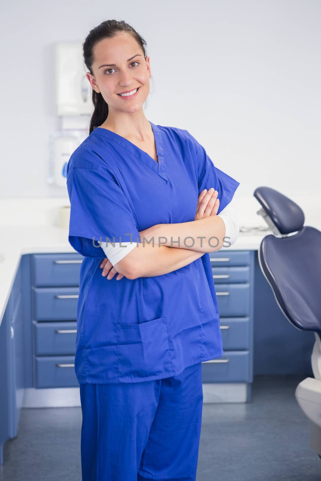 Cheerful dentist standing with arms crossed by Wavebreakmedia