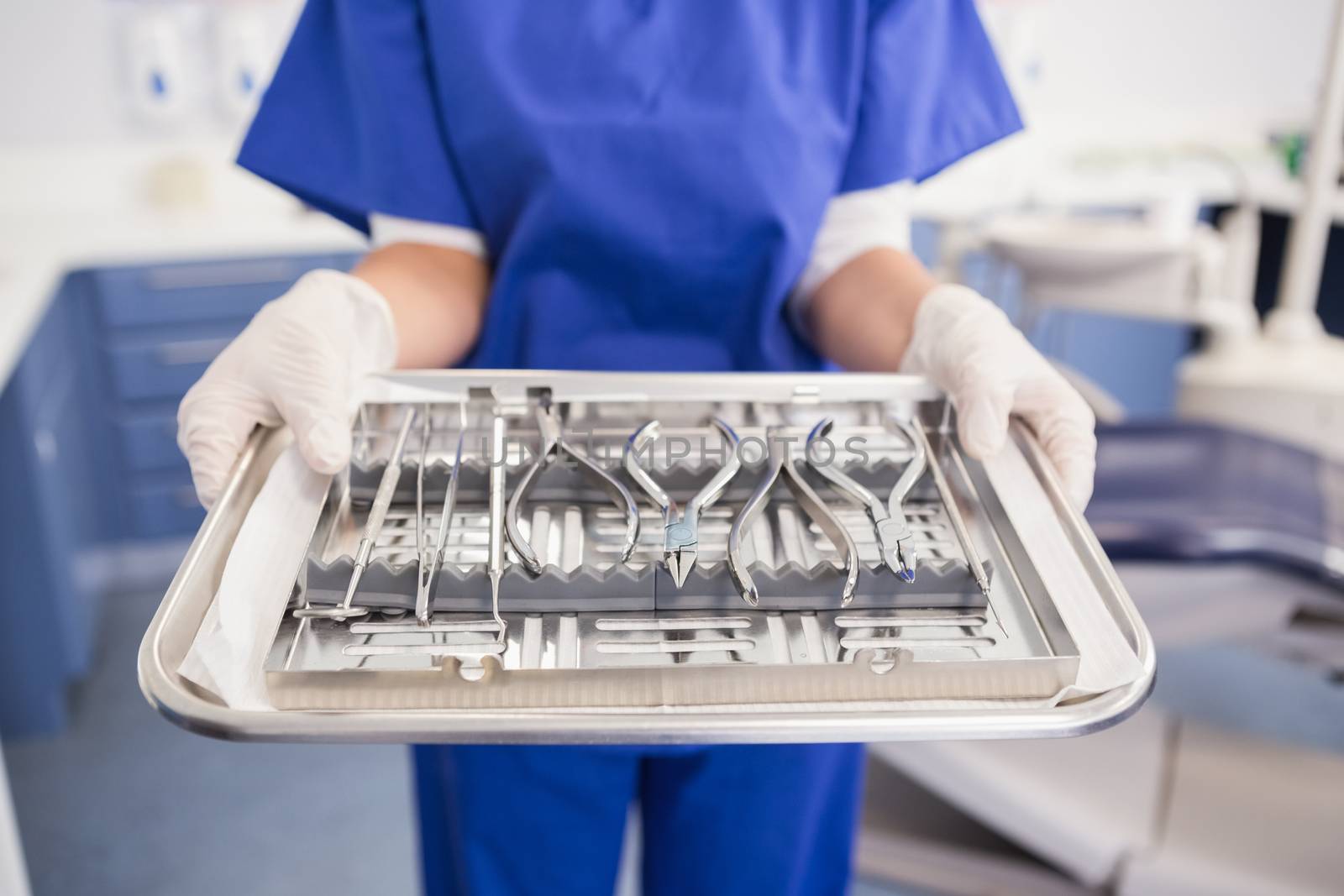 Dentist holding tray with equipment  by Wavebreakmedia