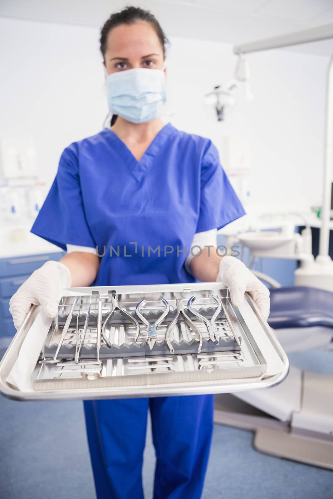 Portrait of a dentist with surgical mask and holding tray by Wavebreakmedia