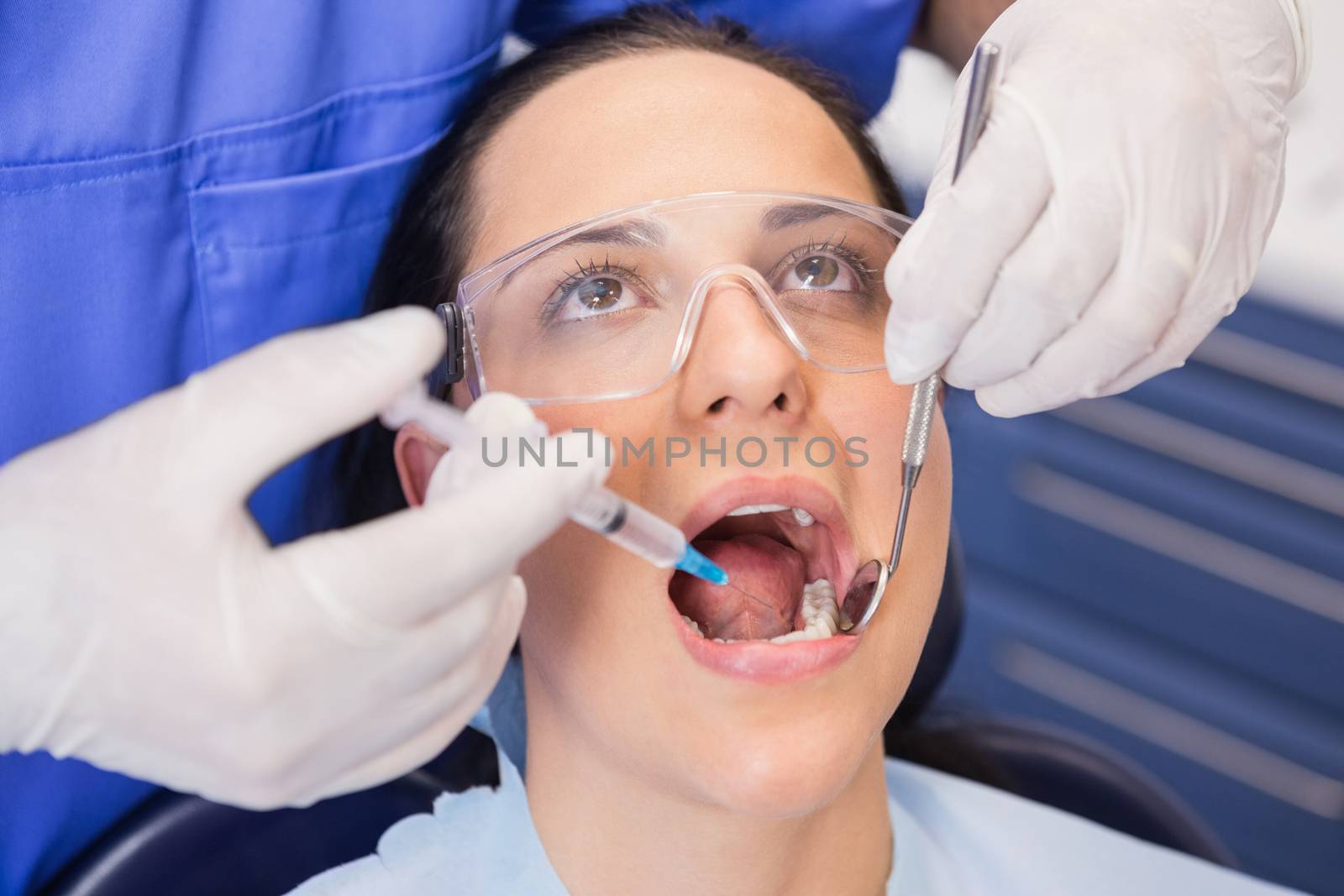 Dentist doing injection to his patient in dental clinic