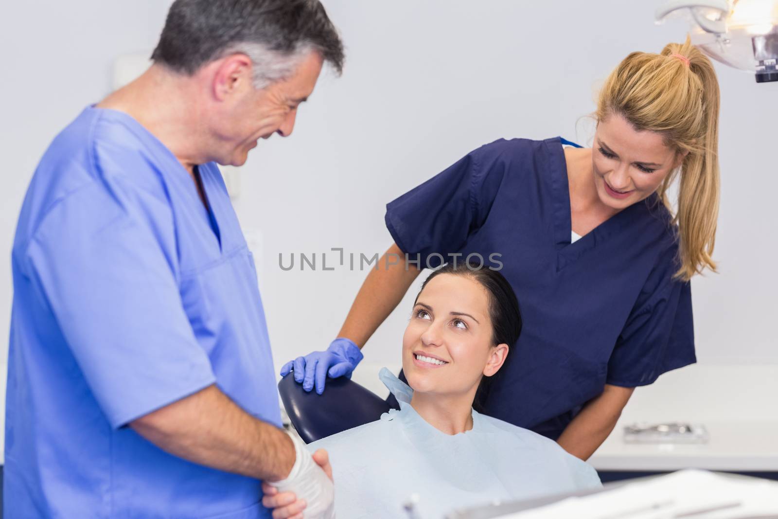 Dentist and nurse introducing a patient in dental clinic