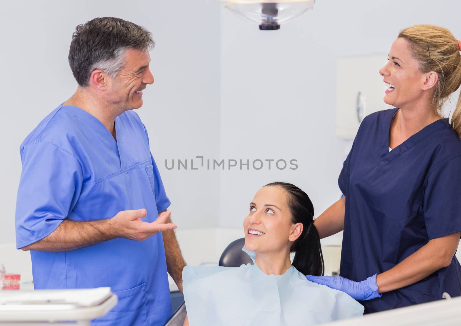 Smiling dentist and nurse speaking with their patient  by Wavebreakmedia