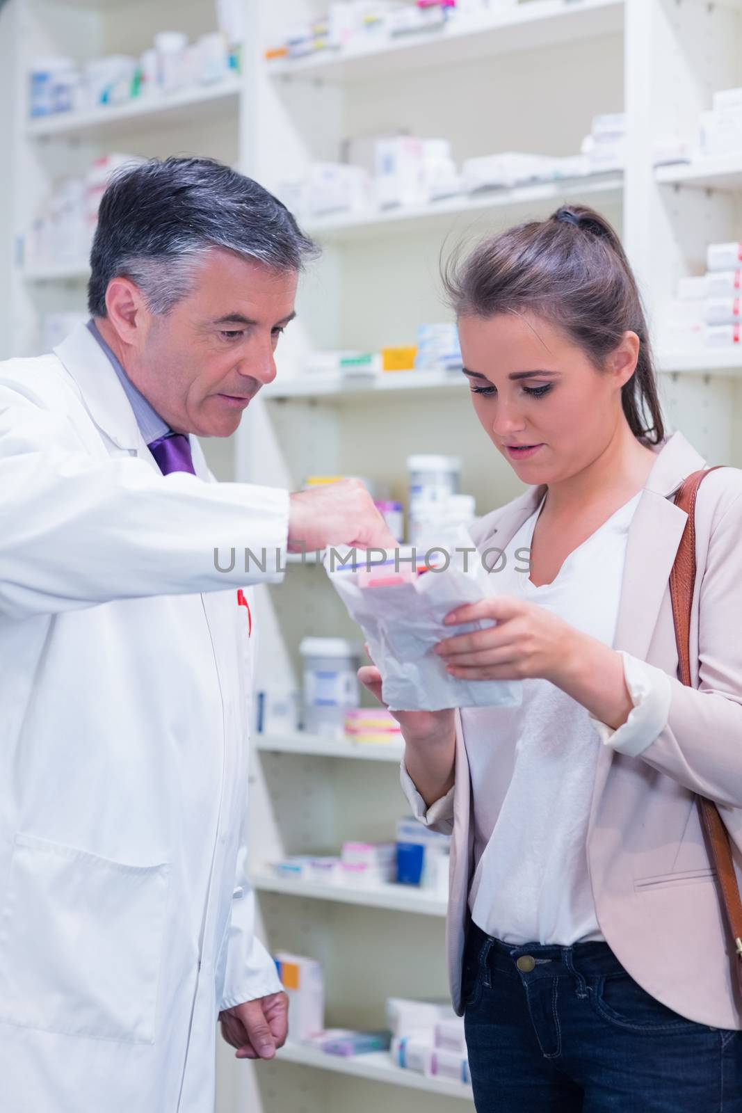 Pharmacist explaining medicine to his customer  by Wavebreakmedia