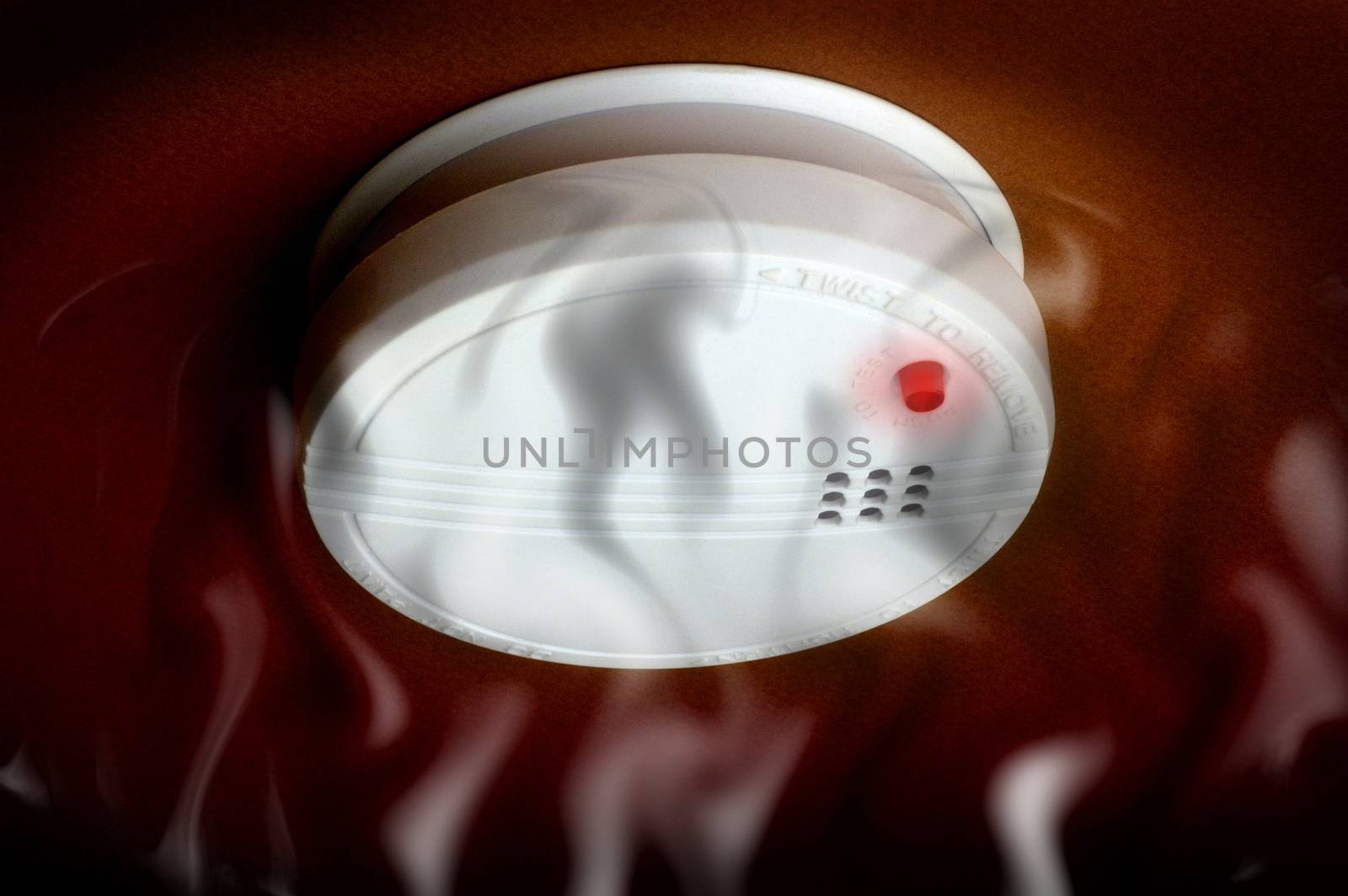 smoke detector with smoke and turned on the red light on a dark brown background