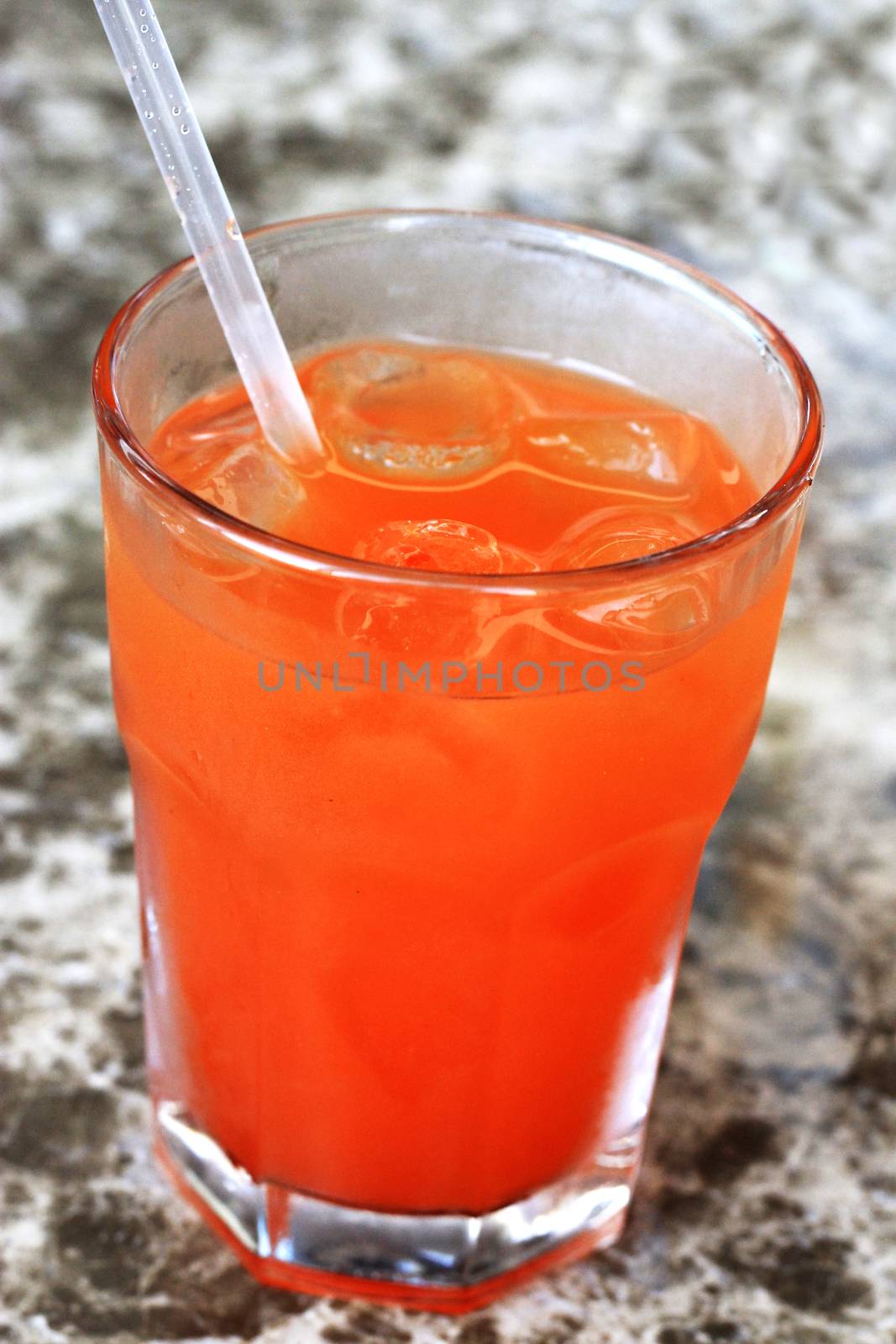 Glass of drink with a straw on the marble table