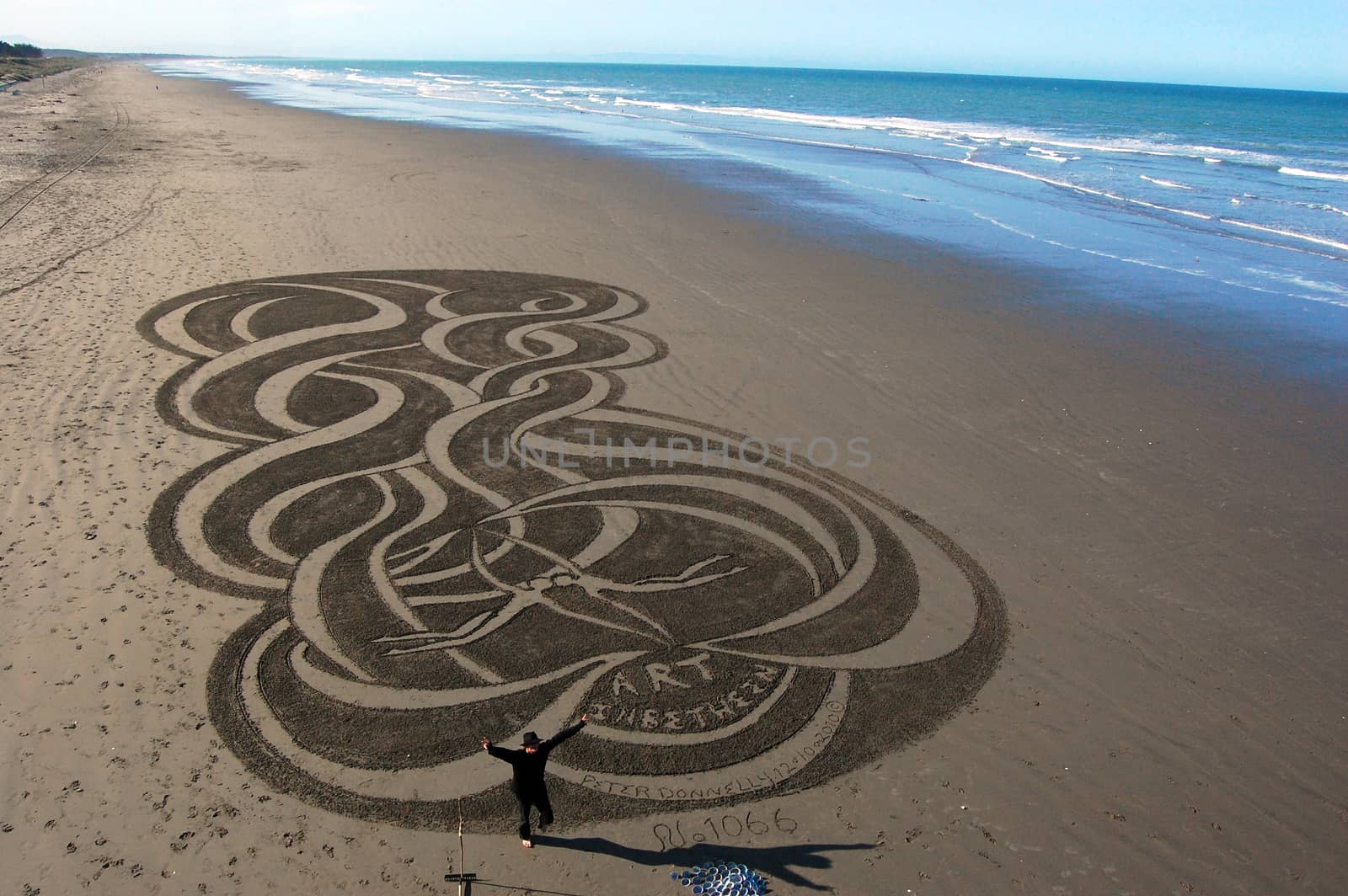 Man with sand picture at town beach, Christchurch, New Zealand