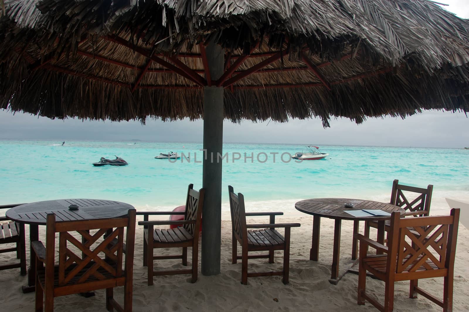 Chairs and tables under big umbrella at beach, Maldives