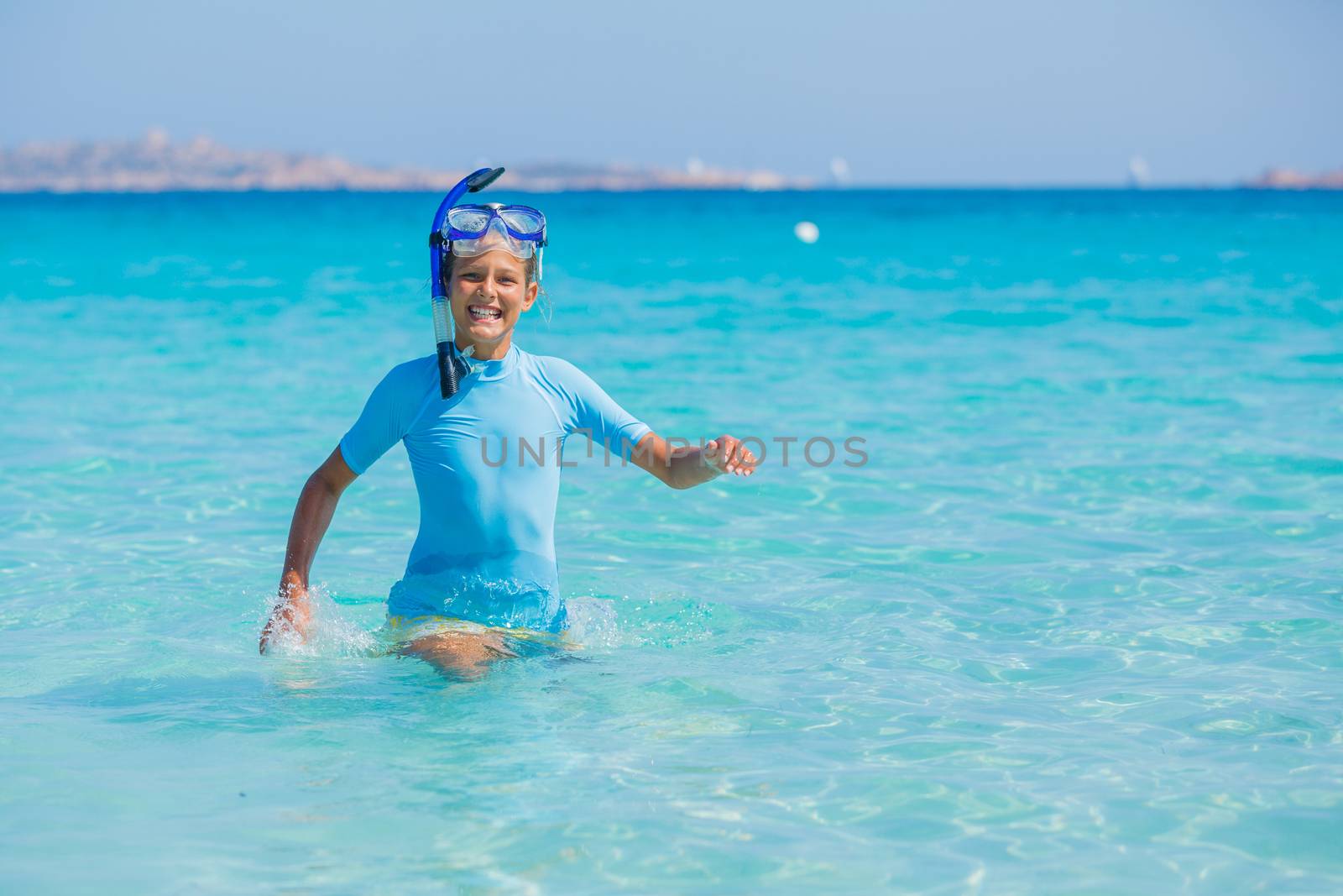 Happy cute girl wearing snorkeling mask ready to dive in the sea