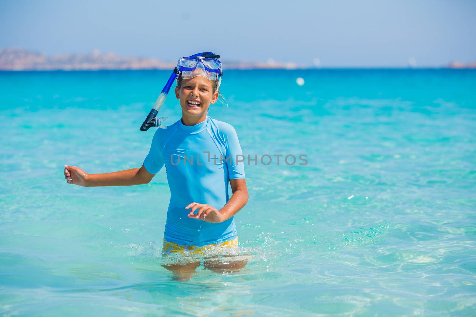 Happy cute girl wearing snorkeling mask ready to dive in the sea