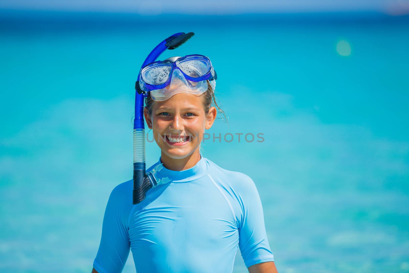 Happy cute girl wearing snorkeling mask ready to dive in the sea