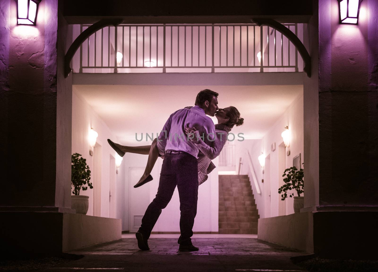 Couple Kissing In Front of Apartment Entrance