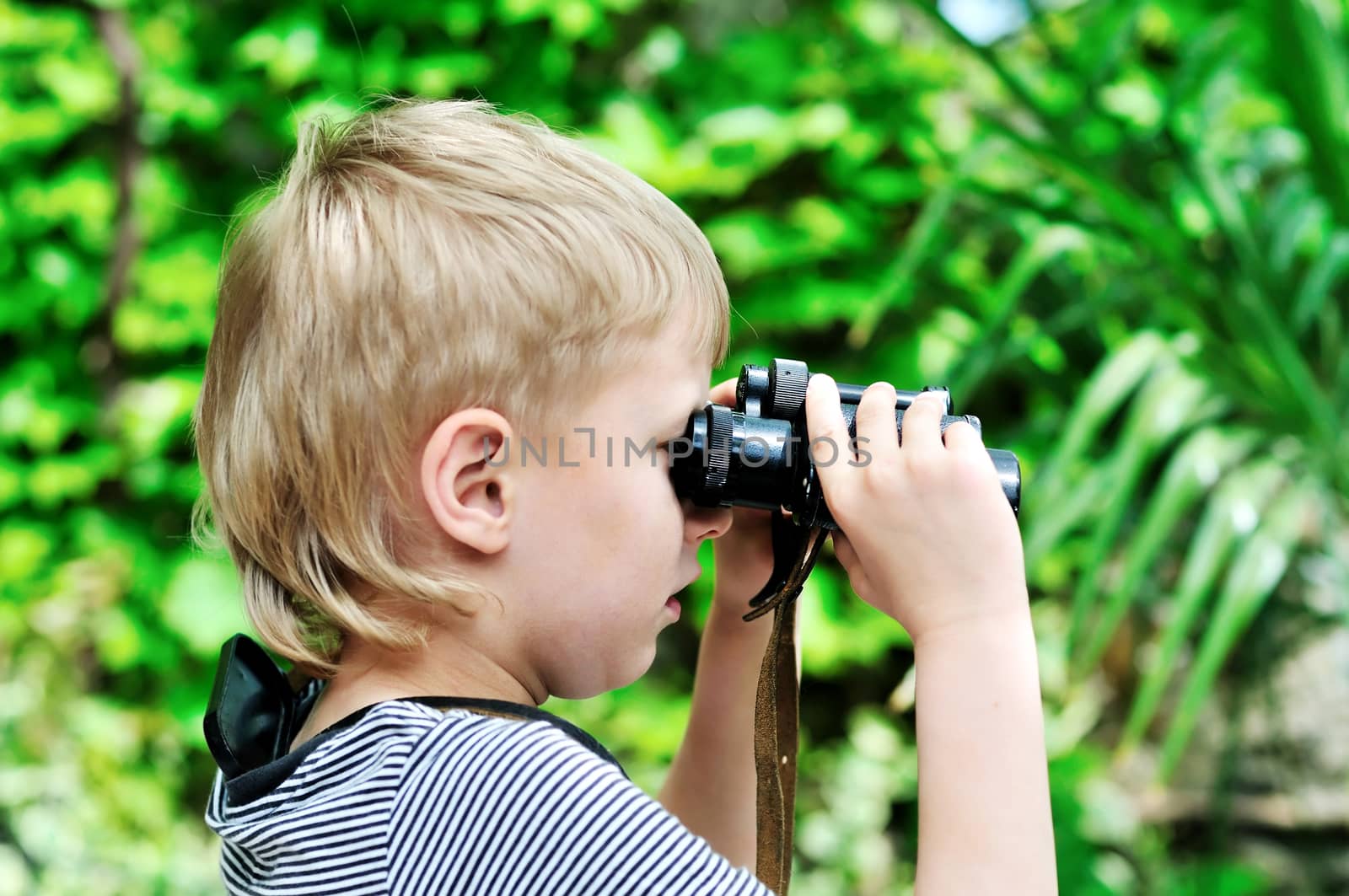 Boy looking through binocular in selective focus 