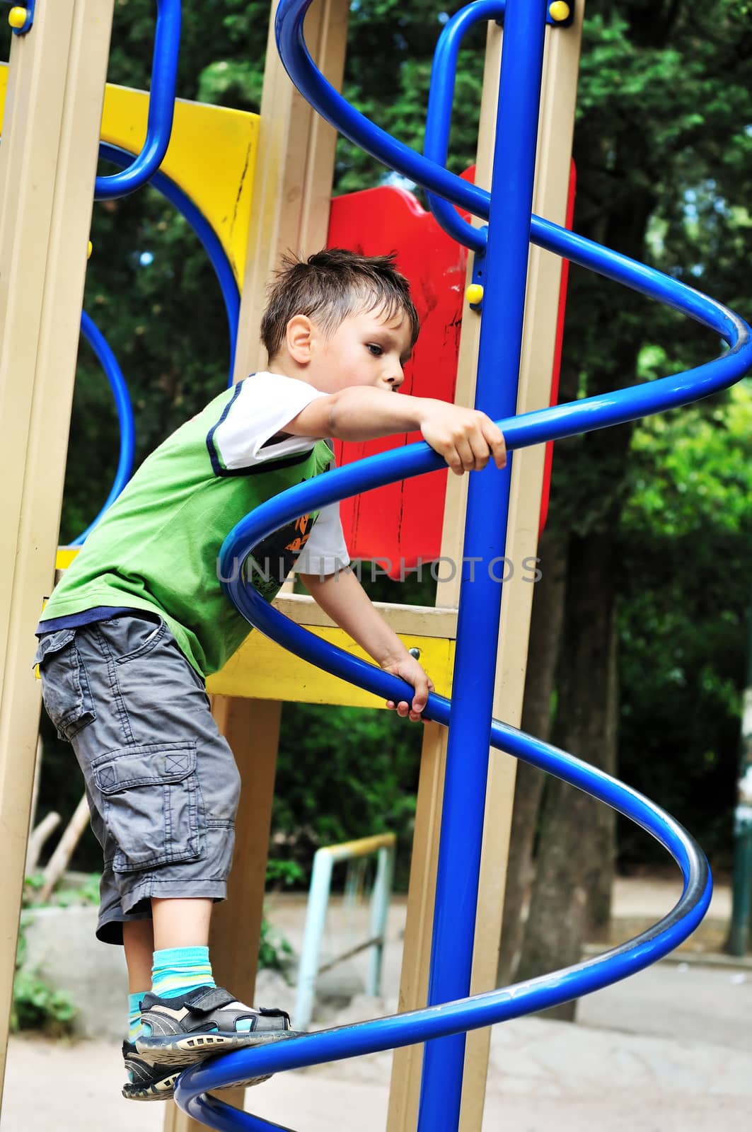active little  boy climbing on the playground