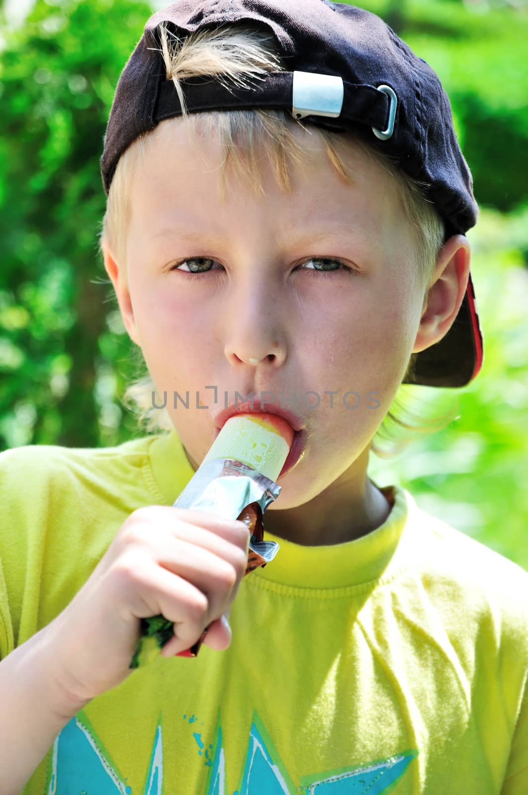  little boy is eating tasty ice-cream  outdoors