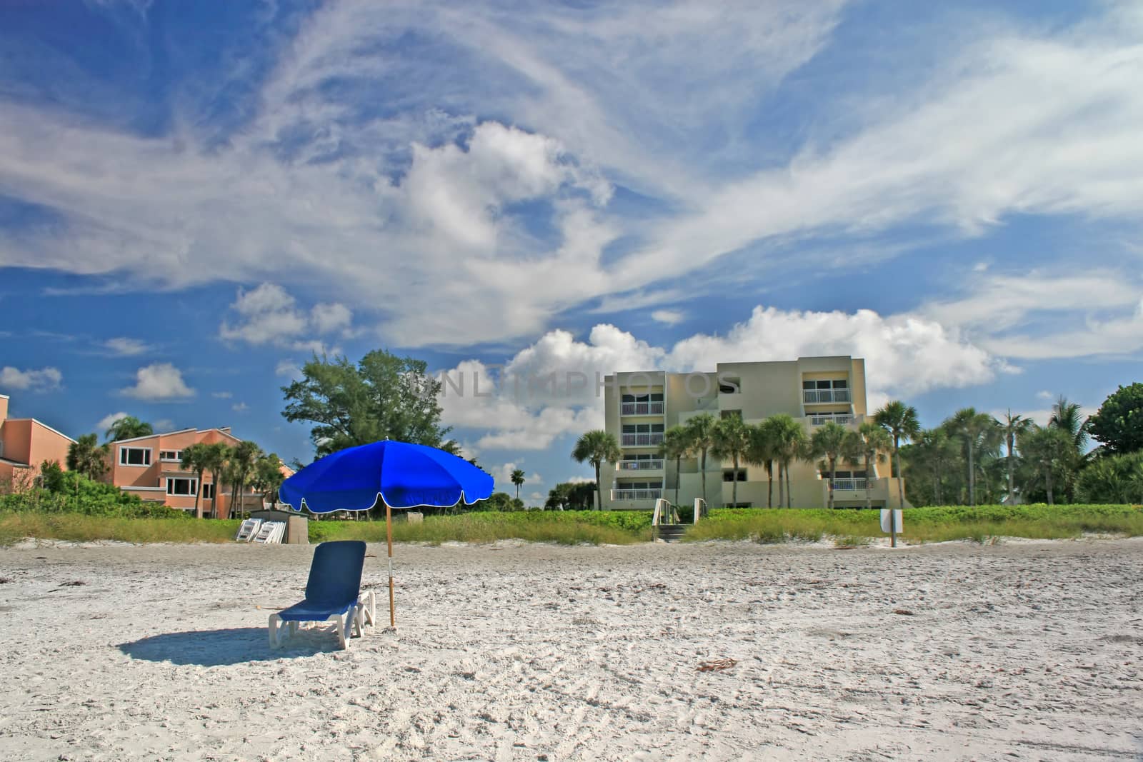 A beach with a chair and umbrella