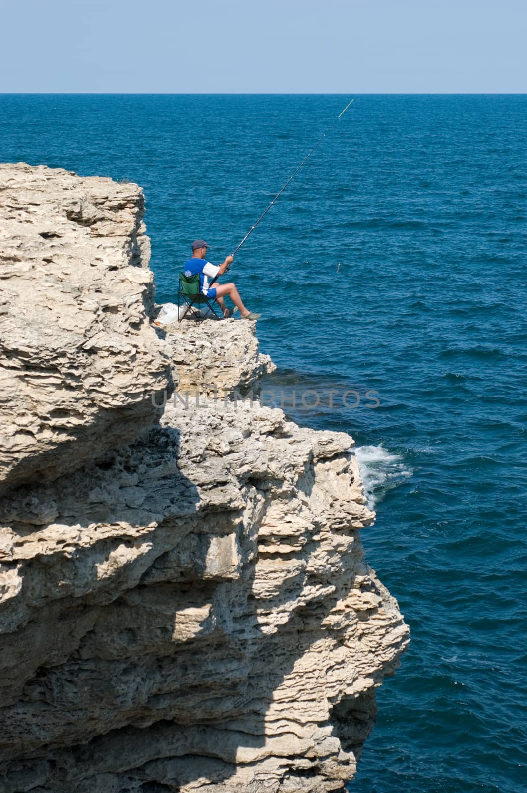 Crimea, Black Sea and the good weather. A man catches a fish.