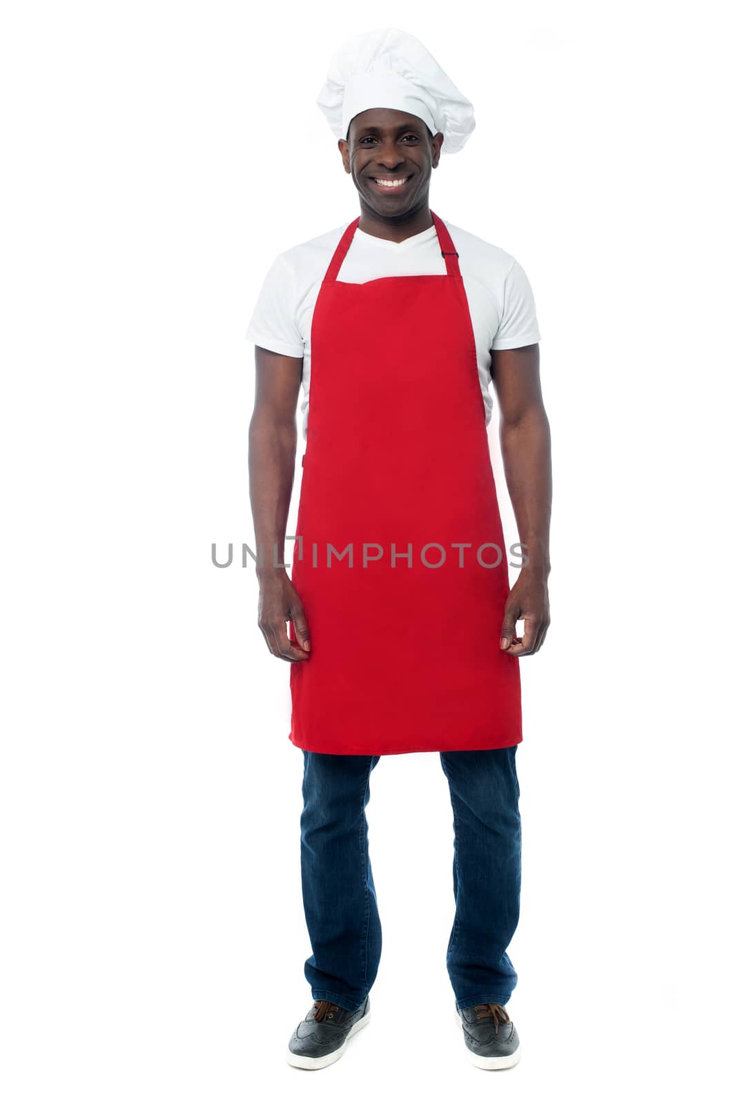 Happy male chef in uniform posing over white