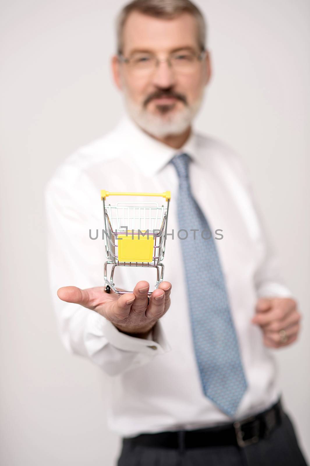 Experienced executive showing mini shopping cart