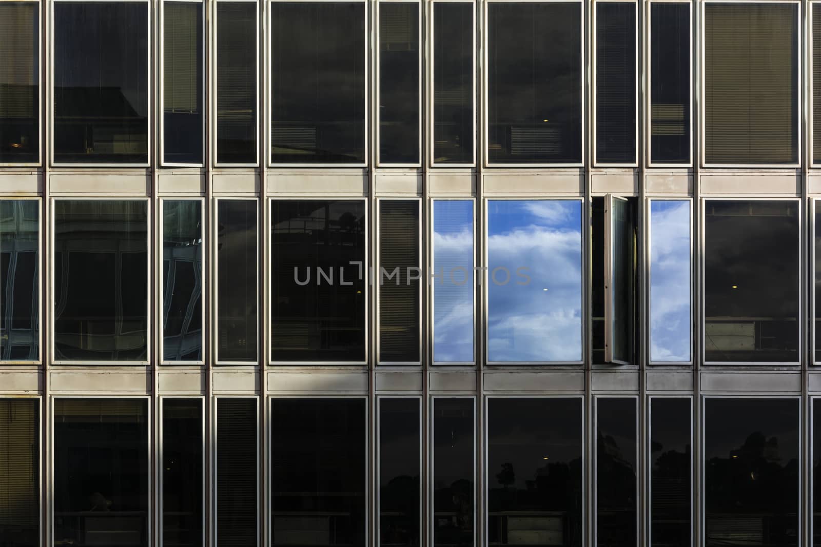 sky and clouds reflected on the windows of a building after a thunderstorm