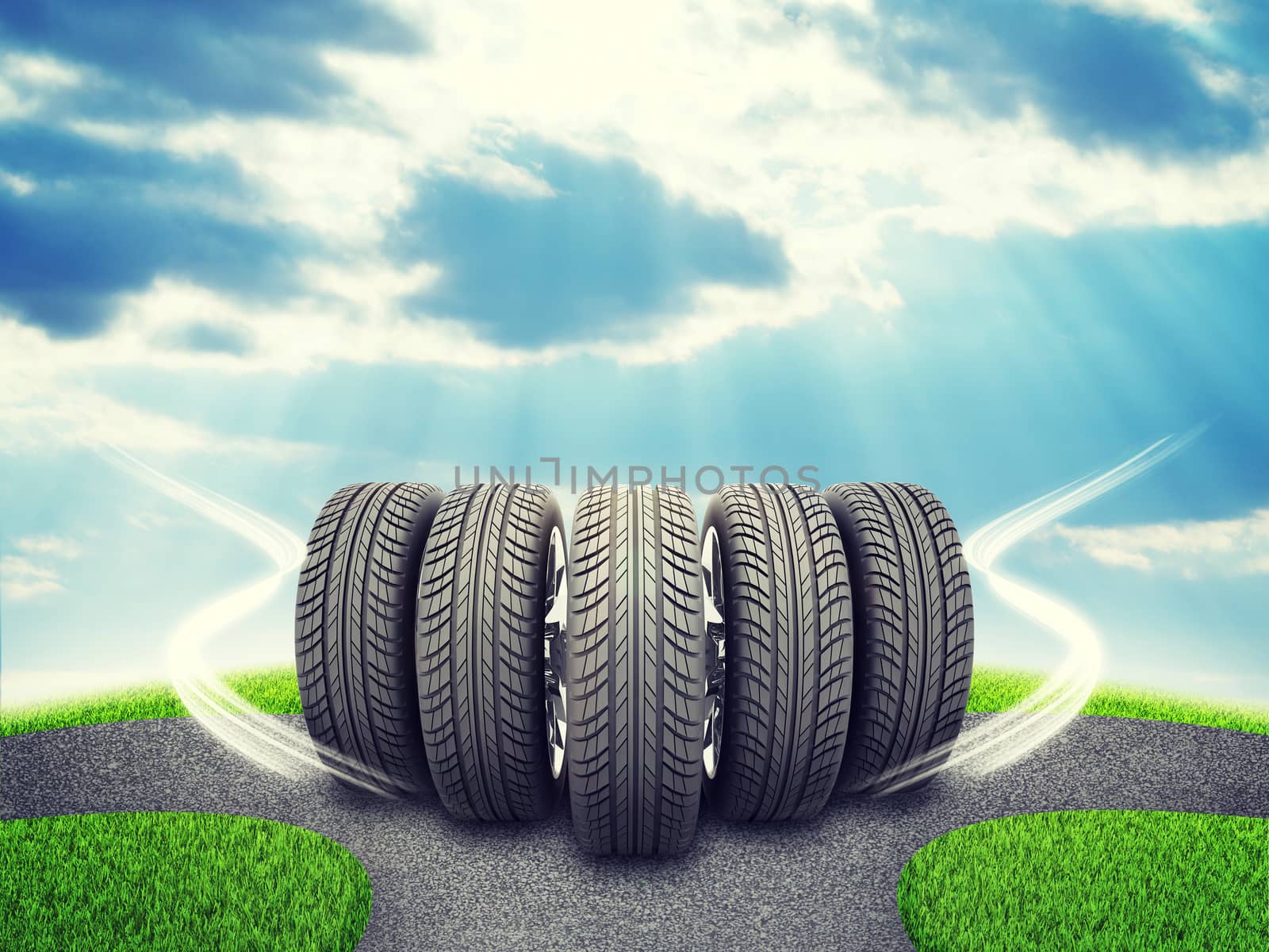 Wedge of new car wheels. Road fork  and green grass field. Sky with clouds and sun beams in background